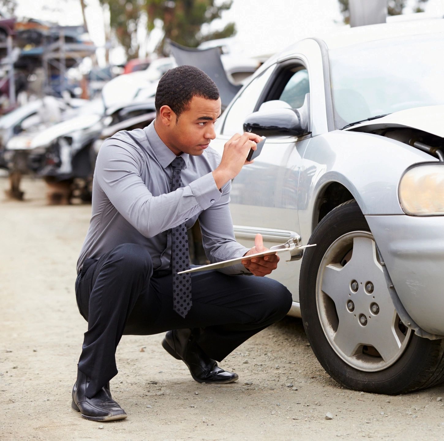 An insurance adjuster reviewing accident damage