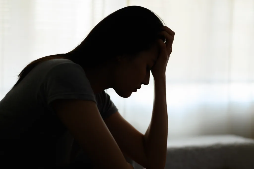 A silhouette of a woman looking upset